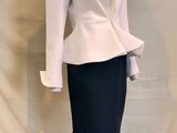 a mannequin wearing a white jacket and black skirt