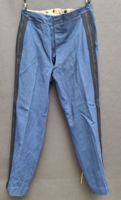 blue and black pants hanging on a hanger on a wall