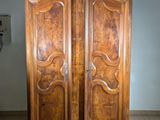 a large wooden armoire in a room with tile flooring