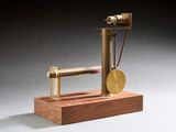 une image représentant une maquette de machine à vapeur posée sur un socle en bois