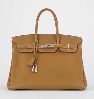 un sac à main en cuir marron muni d'un cadenas sur la poignée