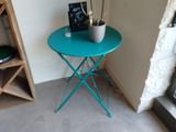a small table with a potted plant on it in the corner of a room