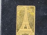 a gold plated eiffel tower in a black box