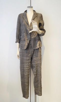 un mannequin vêtu d'un costume et d'un pantalon, posé sur un socle