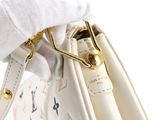 a person holding a white purse with a gold handle