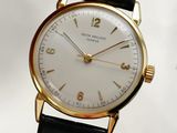 a close up of a gold wrist watch with a white face