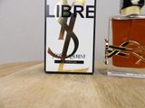 a bottle of libre next to a box of perfume on a table