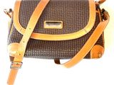 brown and black handbag with tan leather strap on a white background