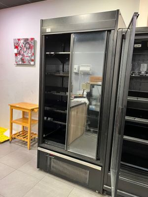 une image d'une cuisine avec un réfrigérateur et une table
