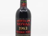 a bottle of red wine sitting on top of a white table