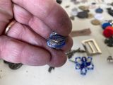 a person holding a ring in their hand with a lot of other things