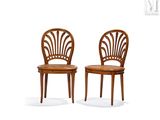 two wooden chairs sitting next to each other on top of a white surface