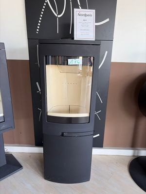 a black stove sitting next to a wall with a sign on it