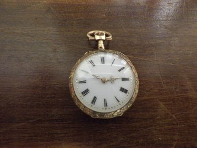 une montre de poche en or avec des chiffres romains