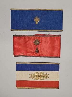 trois rubans de couleurs différentes accrochés les uns à côté des autres sur un mur