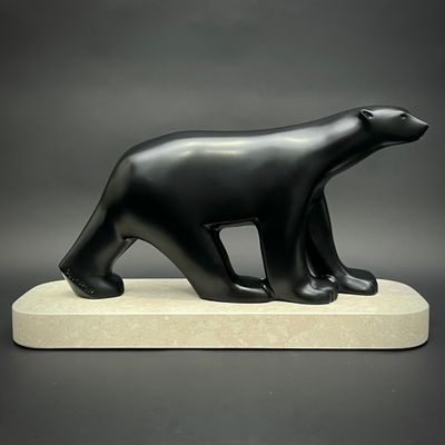 statue d'un ours noir sur un socle blanc, sur fond gris