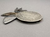 a silver coin with a leaf on top of it