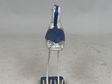 a small metal sculpture of a bird on a stand