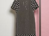 a black and white dress hanging on a rack in front of a pink wall