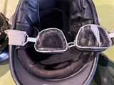 a helmet with goggles and a pair of sunglasses on a table