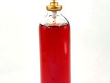 bottle of red liquid on a white background