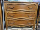 une commode en bois sur laquelle est posé un coussin rayé