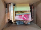 a cardboard box filled with books and papers