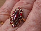 la main d'une femme tenant une bague sertie d'un grenat