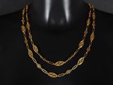 un gros plan sur un mannequin portant un collier à chaîne en or