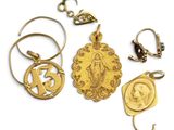 plusieurs bijoux en or, dont une médaille, une pièce de monnaie et un porte-clés