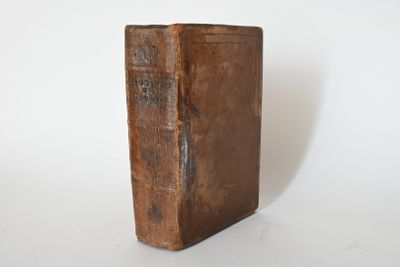 an old book that is sitting on a white surface