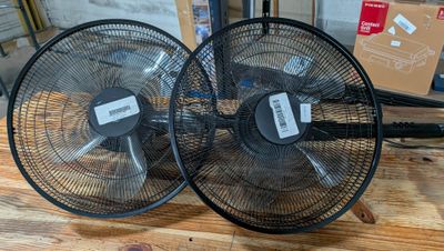 deux ventilateurs posés sur une table en bois
