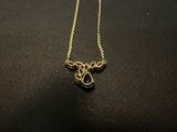 a gold plated necklace with a black and white design on it