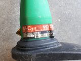 a close up of a green corded blower attached to a wall