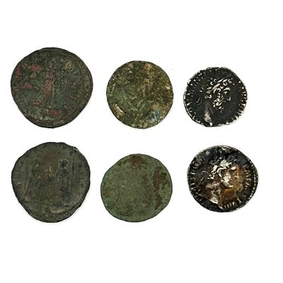 six pièces de monnaie romaines sont alignées sur une surface blanche