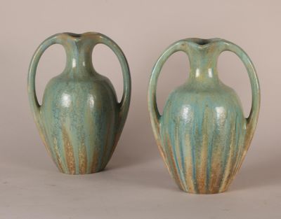 two green vases sitting next to each other on a table