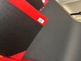 trois livres rouges et noirs posés sur une étagère dans une pièce