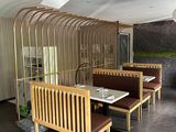 tables and benches in a restaurant with a large screen behind them