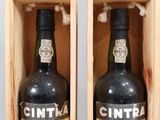 two bottles of wine in a wooden box on a table