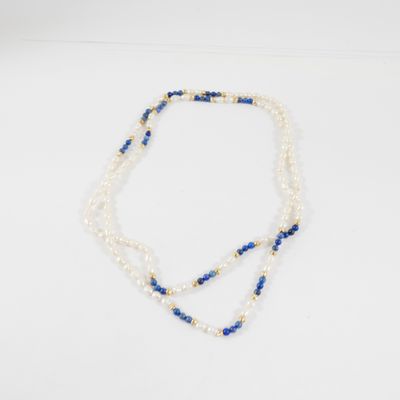 un collier de perles blanches et bleues posé sur un fond blanc