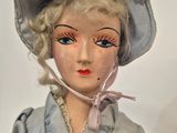 a doll that is wearing a hat and dress