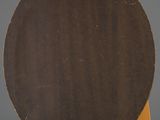 an old wooden chair with a black plate on top of it
