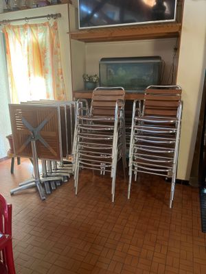 il y a de nombreuses chaises dans la pièce, avec une télévision accrochée au mur