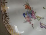un gros plan d'une assiette sur laquelle sont peintes des fleurs