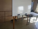 un tableau blanc posé sur un support au milieu d'une pièce