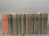 several books are lined up in a row on a gray surface