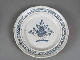 a blue and white plate with a flower design on it