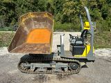 a yellow bulldozer sitting in a gravel lot