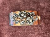 un gros plan sur un bracelet en argent orné de perles