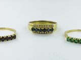 three gold rings with emeralds and diamonds on them